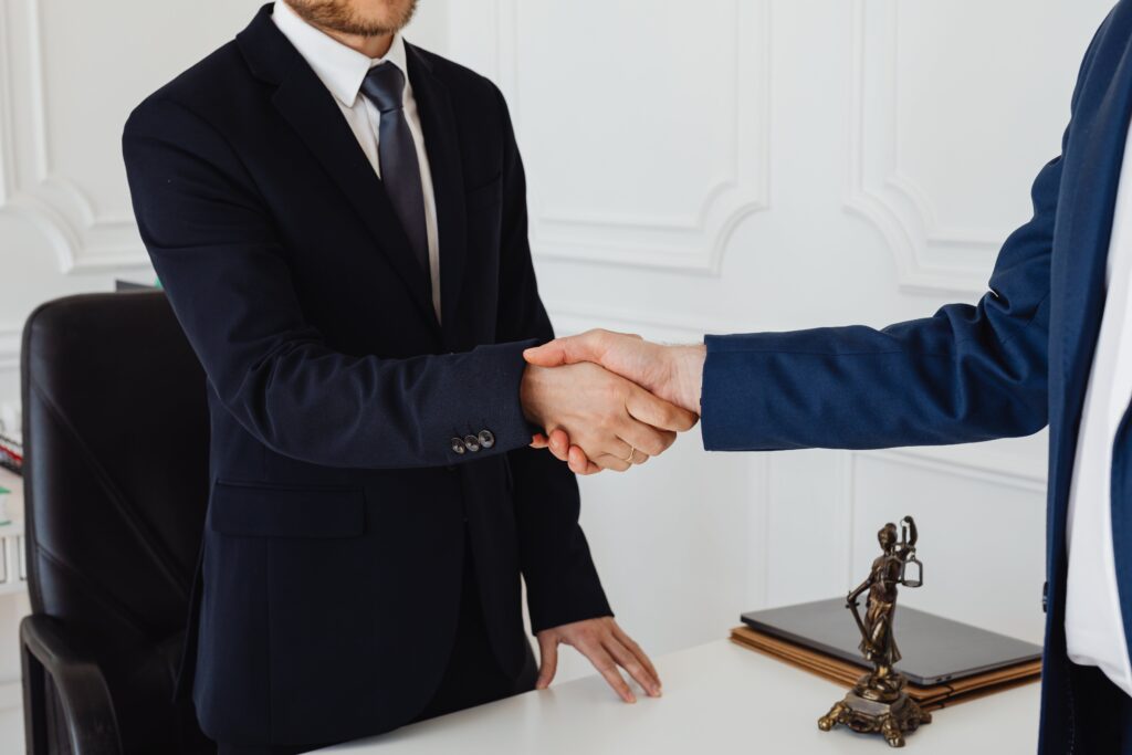 Describe la confianza de contratar un abogado para El abogado inmobiliario genera confianza, Por eso es importante contratarlo, Dos personas sellan un trato dándose las manos